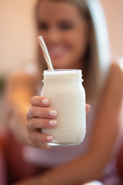 Batido con leche de avena en un bote de cristal con una pajita.