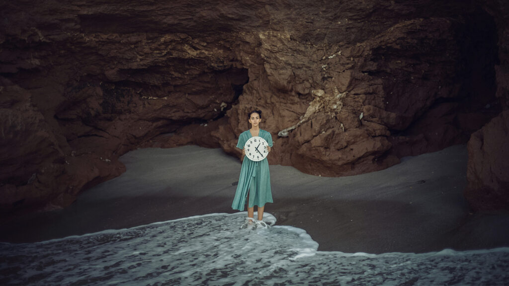 Imagine di Carolina Basi - Donna che posa con l'orologio vicino alle rocce